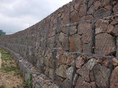 Four layers of woven Galfan gabions are on the ground.