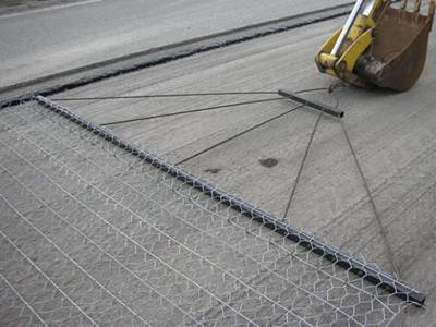 A machine is stretching the road mesh on the road.