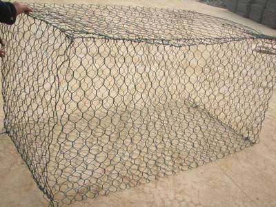 A green color PVC coated gabion box on the ground.