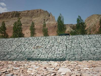 PVC coated gabions are installed on the slope.