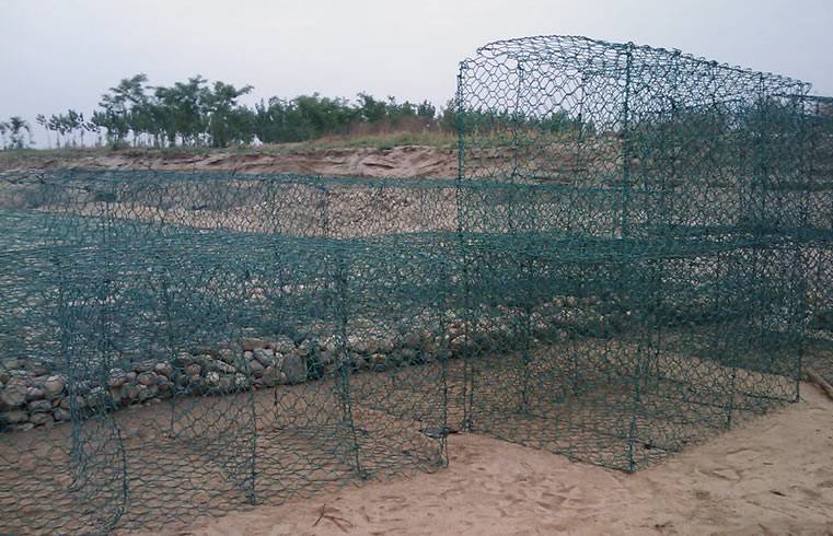 Many green PVC coated gabion boxes without stone filled on the construction site.