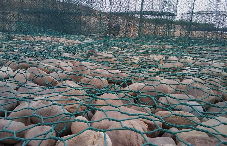 Dark green PVC coated galvanized wire netting gabion boxes for Putuo river bank protection, and some empty boxes are piled up together.