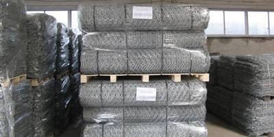 Several pallet of hexagonal wire mesh rolls with pallet and plastic film package on the ground.