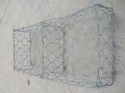 A gray color PVC coated woven gabion mattress on the ground.